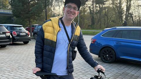 Gewinner Kai mit seinem neuen E-Bike auf dem Parkplatz der Sporthalle An der Düne
