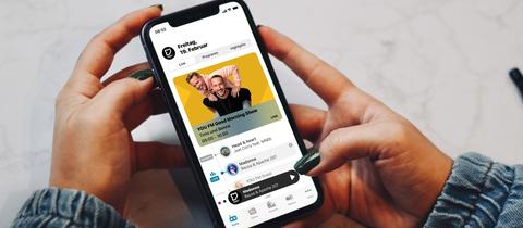 Smartphone mit der neuen YOU FM-App