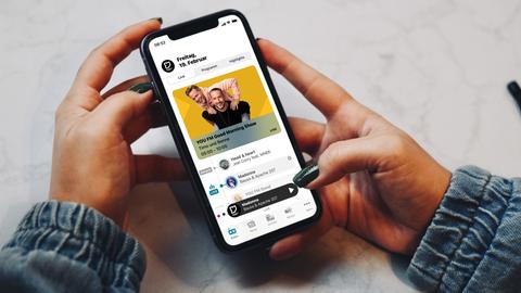 Smartphone mit der neuen YOU FM-App