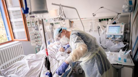 Ein Intensivpfleger arbeitet auf der Intensivstation eines Krankenhauses an einer an Covid-19 erkrankten Patientin. 