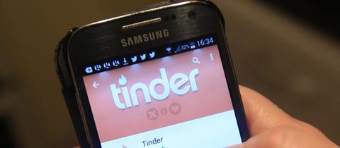 Ein Smartphone zeigt die Tinder-App an. 
