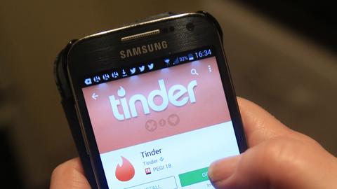 Ein Smartphone zeigt die Tinder-App an. 