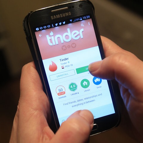 Ein Smartphone zeigt die Tinder-App an. 